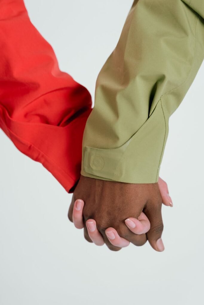 pexels-photo-7009499-7009499 A close-up of two people holding hands, showcasing diversity and unity.